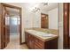 Bathroom featuring double sinks, wood cabinets, tile countertops and floors at 26426 E Peakview Dr, Aurora, CO 80016