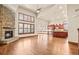 Open-concept living room with vaulted ceiling, wood floors, stone fireplace, and adjacent kitchen at 26426 E Peakview Dr, Aurora, CO 80016