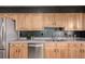 The kitchen features stainless steel appliances, wooden cabinets, and a tiled backsplash at 1745 S Kline Way, Lakewood, CO 80232