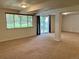 A large, carpeted basement area provides an open layout with natural light from windows and doors at 10369 E Red Mtn, Littleton, CO 80127