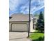 Exterior view of a home featuring an attached garage, well-kept lawn, and neatly landscaped front yard at 10369 E Red Mtn, Littleton, CO 80127