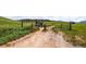 Gated entrance to open space with informational signage, marking the beginning of a scenic trail at 10369 E Red Mtn, Littleton, CO 80127