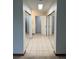 Hallway with neutral tile flooring, double mirrored closets, and convenient access to other rooms at 10369 E Red Mtn, Littleton, CO 80127