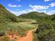 Picturesque hiking trail through green hills and natural landscapes, perfect for outdoor enthusiasts at 10369 E Red Mtn, Littleton, CO 80127