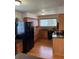 Well-lit kitchen featuring wood cabinets, granite countertops, and modern black appliances at 10369 E Red Mtn, Littleton, CO 80127