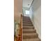 Carpeted staircase with wooden banister leading to the upper level, featuring natural light at 10369 E Red Mtn, Littleton, CO 80127