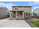 Rear exterior view of the home featuring a porch and stone accents at 26267 E 3Rd Ave, Aurora, CO 80018