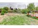 Large, grassy backyard with brick planters on a hill and partial view of the neighborhood at 9743 W 67Th Pl, Arvada, CO 80004