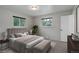 A serene bedroom with large windows, plush bedding, neutral tones, and a cozy sitting area at 9743 W 67Th Pl, Arvada, CO 80004