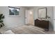 Stylish bedroom featuring a modern dresser, neutral tones, and a well-lit ensuite bathroom at 9743 W 67Th Pl, Arvada, CO 80004