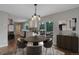 Open dining room with a modern light fixture that leads to the kitchen and outdoor patio at 9743 W 67Th Pl, Arvada, CO 80004