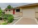Charming single-story home featuring a red front door and an attached one car garage at 9743 W 67Th Pl, Arvada, CO 80004
