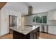 Bright kitchen featuring an island with granite countertops, stainless steel appliances and white cabinets at 9743 W 67Th Pl, Arvada, CO 80004