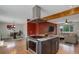 Open concept kitchen with island cooktop and stainless hood, connecting the dining and living room areas at 9743 W 67Th Pl, Arvada, CO 80004