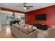 Open floorplan living room with hardwood floors, ceiling fan, and a red accent wall at 9743 W 67Th Pl, Arvada, CO 80004