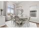 Dining room with an oval table set for a meal, modern lighting, and large windows at 21972 E Allenspark Dr, Aurora, CO 80016