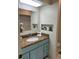 Bathroom with blue vanity features granite countertop, large mirror, and recessed shelving at 2724 S Ames Way, Denver, CO 80227
