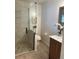 The remodeled bathroom features a glass shower with river rock floor and wood-look tile at 2724 S Ames Way, Denver, CO 80227