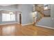 Open-concept living area with hardwood floors, staircase, and elegant chandelier at 4453 W Mountain Vista Ln, Castle Rock, CO 80109