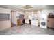 Kitchen featuring open shelving, appliances, and access to the laundry area at 4263 S Elati St, Englewood, CO 80110