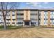Exterior view of the well-maintained building with a manicured front lawn at 615 S Alton Way # 7A, Denver, CO 80247