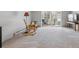Bright living room with sliding glass doors, rocking chair, and plush carpeting at 615 S Alton Way # 7A, Denver, CO 80247