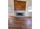 Spacious living room featuring hardwood floors and a rustic fireplace at 14425 E Albrook Dr, Denver, CO 80239