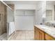 Bright bathroom featuring a walk-in shower, granite counters, and open shelving at 7238 W Cedar Cir, Lakewood, CO 80226