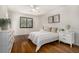 This bedroom has white walls, hardwood floors, a ceiling fan, and a large window for natural light at 7238 W Cedar Cir, Lakewood, CO 80226
