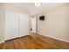 Bedroom featuring wood floors, closet with sliding doors, and a mounted TV at 7238 W Cedar Cir, Lakewood, CO 80226