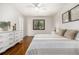 Bright bedroom featuring wood floors, a ceiling fan, white dresser, and natural light from the window at 7238 W Cedar Cir, Lakewood, CO 80226