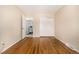 Bright bedroom with hardwood floors, sliding closet doors, and a doorway to another room at 7238 W Cedar Cir, Lakewood, CO 80226