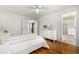 Bright bedroom featuring wood floors, a ceiling fan, white dresser, and an ensuite bathroom at 7238 W Cedar Cir, Lakewood, CO 80226