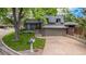 Brick home featuring an attached garage, well-kept lawn, and mature shade trees at 7238 W Cedar Cir, Lakewood, CO 80226