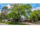Charming brick home featuring an attached garage, manicured front lawn, and a mature tree in yard at 7238 W Cedar Cir, Lakewood, CO 80226