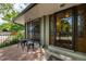 Inviting front porch area featuring a small table with chairs and stylish glass front door at 7238 W Cedar Cir, Lakewood, CO 80226