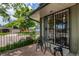 Inviting front porch area featuring a small table with chairs and security bars on the window at 7238 W Cedar Cir, Lakewood, CO 80226