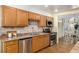 This kitchen features wooden cabinets, stainless steel appliances, granite countertops, and hardwood floors at 7238 W Cedar Cir, Lakewood, CO 80226