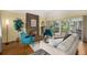 This living room has a brick fireplace, a tan sofa, two blue armchairs, and a sliding glass door at 7238 W Cedar Cir, Lakewood, CO 80226