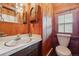 Rustic bathroom with wood walls, marble countertops, and wood accents at 8409 S Otis St, Littleton, CO 80128