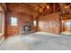 Spacious living room featuring a brick fireplace, wood paneling, and high ceilings with exposed beams at 8409 S Otis St, Littleton, CO 80128