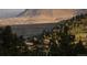 Scenic landscape view with rolling hills, trees, and a distant mountain range under a clear sky at 53 Canyon Pines Dr, Golden, CO 80403