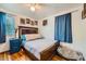 Cozy bedroom featuring hardwood floors, ceiling fan, and a comfortable bed with charming decor at 5424 Saulsbury Ct, Arvada, CO 80002