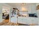 Functional kitchen featuring white cabinetry and stainless sink, adjacent to the home's comfortable living area at 5424 Saulsbury Ct, Arvada, CO 80002