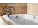 Close up of white bathtub with tiled surround and chrome faucet fixtures at 425 S Reed St, Lakewood, CO 80226