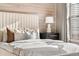 A well-lit bedroom showcasing a comfortable bed, decorative pillows, and a lamp on the nightstand at 425 S Reed St, Lakewood, CO 80226