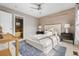 Comfortable bedroom with wood accent wall; featuring a ceiling fan and an attached bathroom at 425 S Reed St, Lakewood, CO 80226