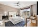 A stylish bedroom featuring a wood-paneled wall, a ceiling fan, and a large window at 425 S Reed St, Lakewood, CO 80226