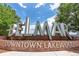 Bellmar, Downtown Lakewood signage with beautiful green trees and brick wall beneath a sunny, partly cloudy sky at 425 S Reed St, Lakewood, CO 80226