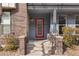 Inviting entrance featuring a red door, brick accents, and well-maintained landscaping at 425 S Reed St, Lakewood, CO 80226